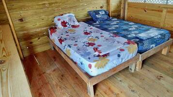 A wooden bed with floral bedding in a cabin-style room.