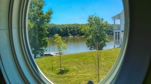 A lake view through a window, with a dock and a small building on the shore. - Panoramic Views of the Illinois Waterway (Ottawa)