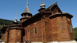 Une église traditionnelle en bois, dotée d’un clocher et de croix.