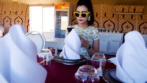 A dining area with a table set for two, featuring white napkins and clear glassware. - Itran Royal Camp (Taouz)