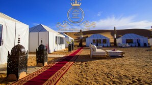 A desert camp with white tents, a red carpet, and traditional lanterns. - Itran Royal Camp (Taouz)