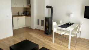 Une cuisine moderne avec des meubles blancs, une cuisinière et un coin repas comprenant une table et des chaises.