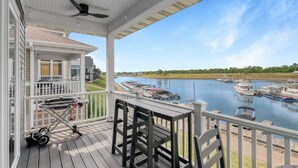 A covered deck with a view of a marina and boats.