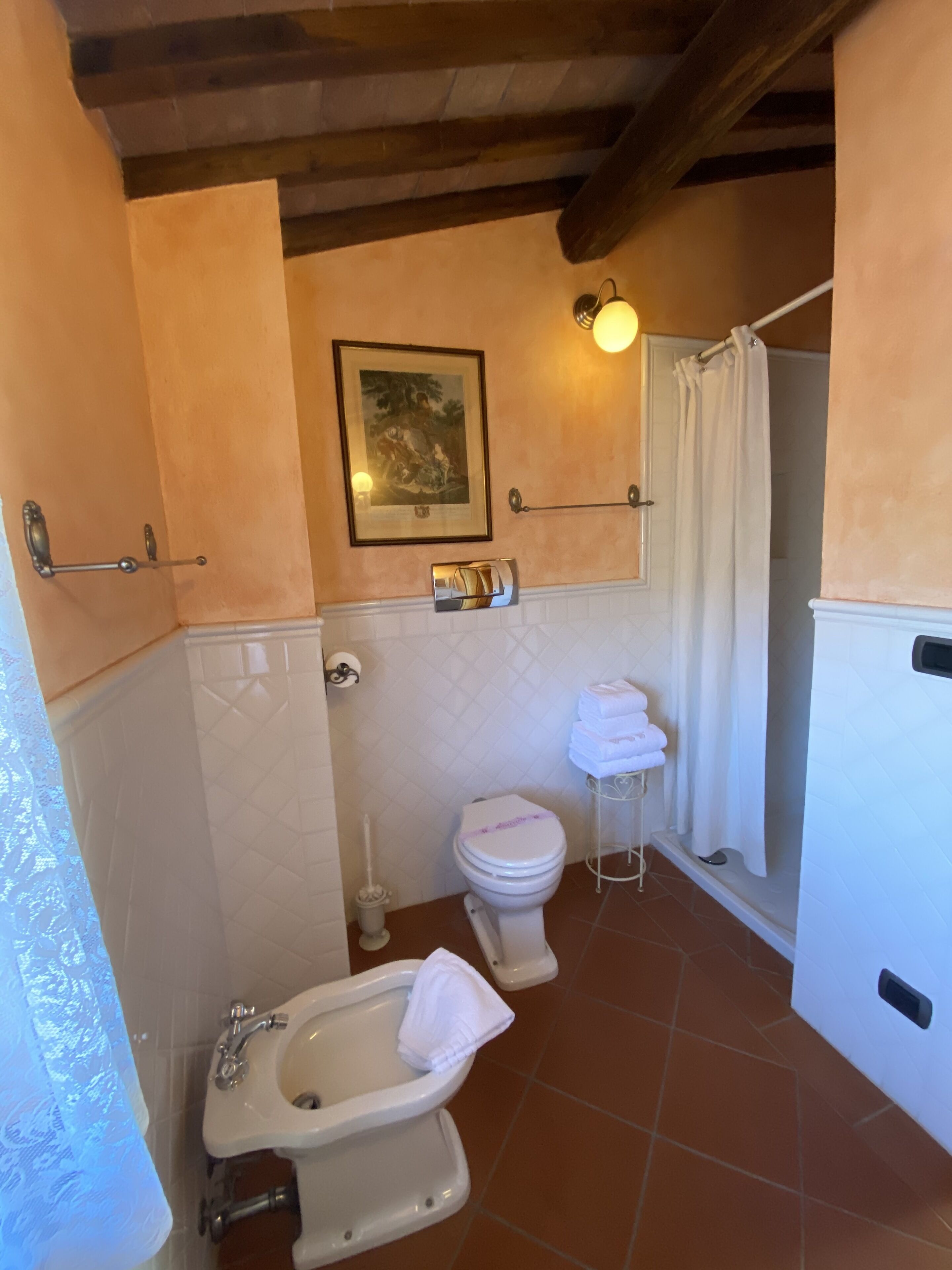 Une salle de bain équipée d’un bidet, de toilettes et d’un rideau de douche.