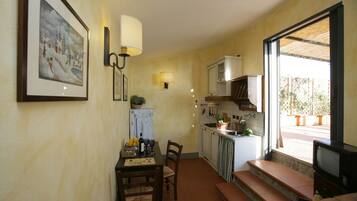 A compact kitchen with a dining area, a TV, and a window with a view of the outside.