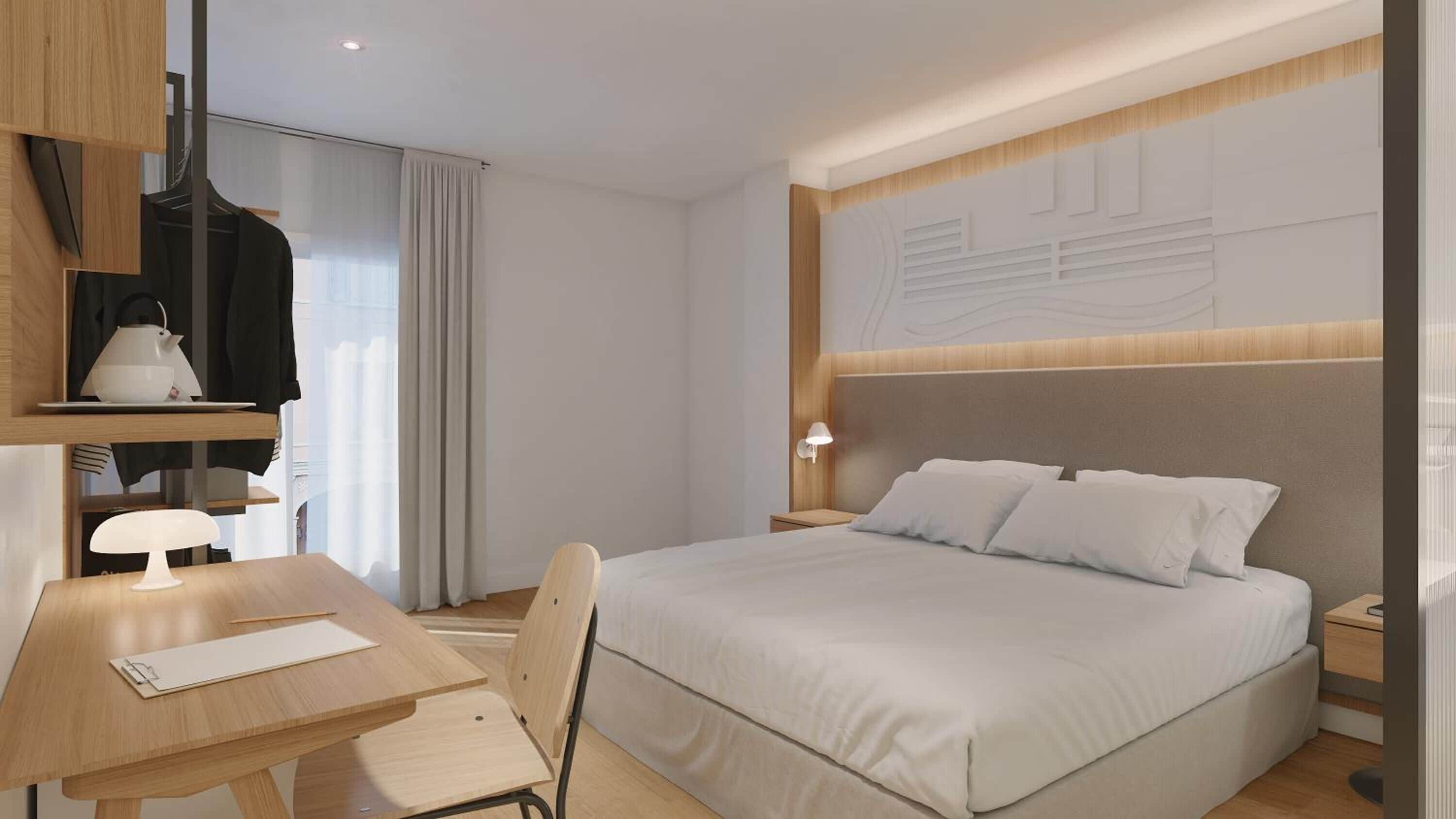 Moderni hotellihuone, jossa on suuri sänky, työpöytä tuolilla, lamppu ja vaatekaappi.