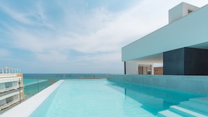 A modern infinity pool with a clear view of the ocean, a white building with a flat roof, and a staircase leading down to the pool. - Senator Cala Millor Hotel (Son Servera)