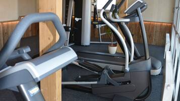 Una palestra con attrezzi da ginnastica, travi in legno e una pianta in vaso.