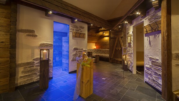 A rustic interior with stone walls, wooden beams, and a blue-lit entrance. - Landgasthof Hotel Rössle (Boehmenkirch)