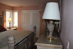 A bedroom with a bed, a dresser, a lamp, and a mirror. - NEW LISTING! Beachfront Villa (Manasquan)