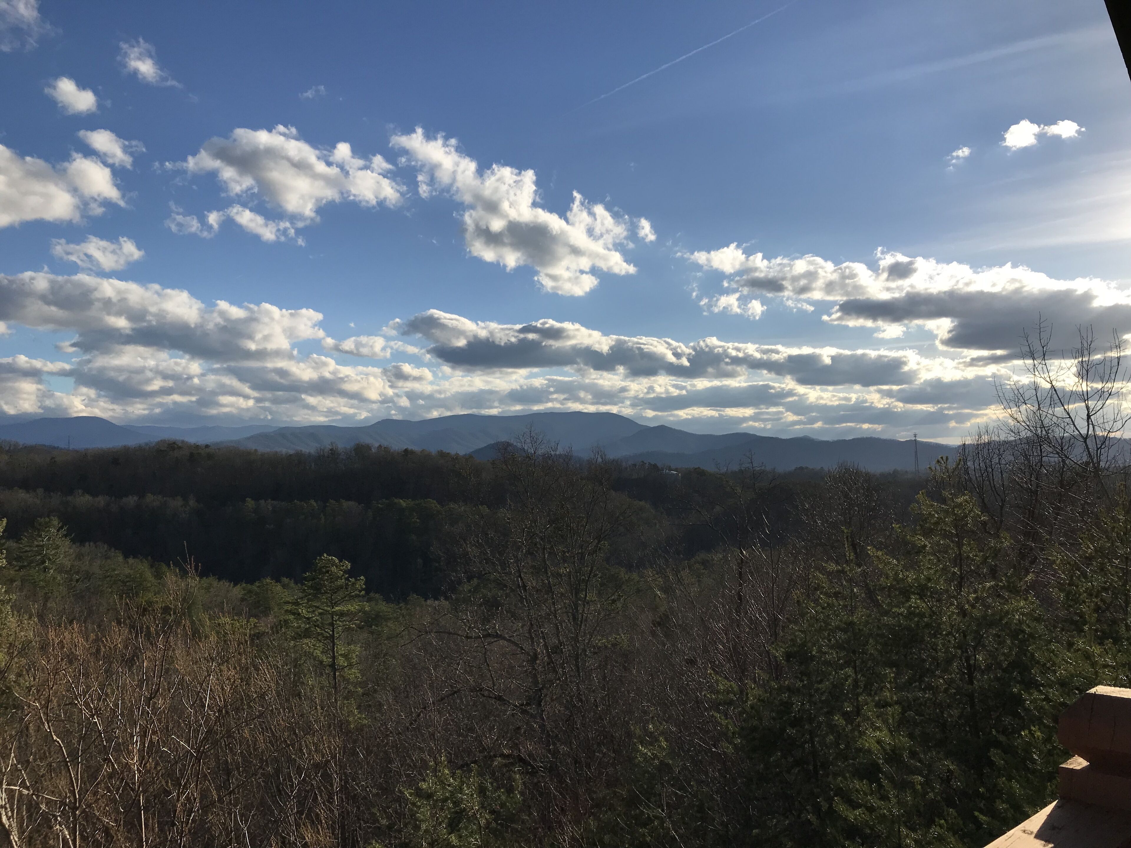 A mountainous landscape with a clear sky and scattered clouds.