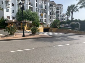 A multi-story residential building with balconies, a gated entrance, and a sign reading "MARINA DE LA DUQUES". - Luxurious and bright apartment on the Costa del Sol (Puerto de la Duquesa)