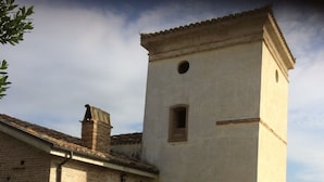 A rustic building with a tower, brick walls, and a staircase leading to a door. - Agriturismo Torre Mannella (Citta Sant'Angelo)