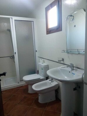 A bathroom with a toilet, bidet, sink, and a shower area. - Résidence Tamuda Golf (M'diq)