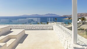 A coastal terrace with a stone wall and steps leading to a white pergola overlooking the sea. - Mykonos Earth Suites - Adults Only (Mykonos)