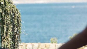 A person meditating with a view of the sea and mountains in the background. - Mykonos Earth Suites - Adults Only (Mykonos)