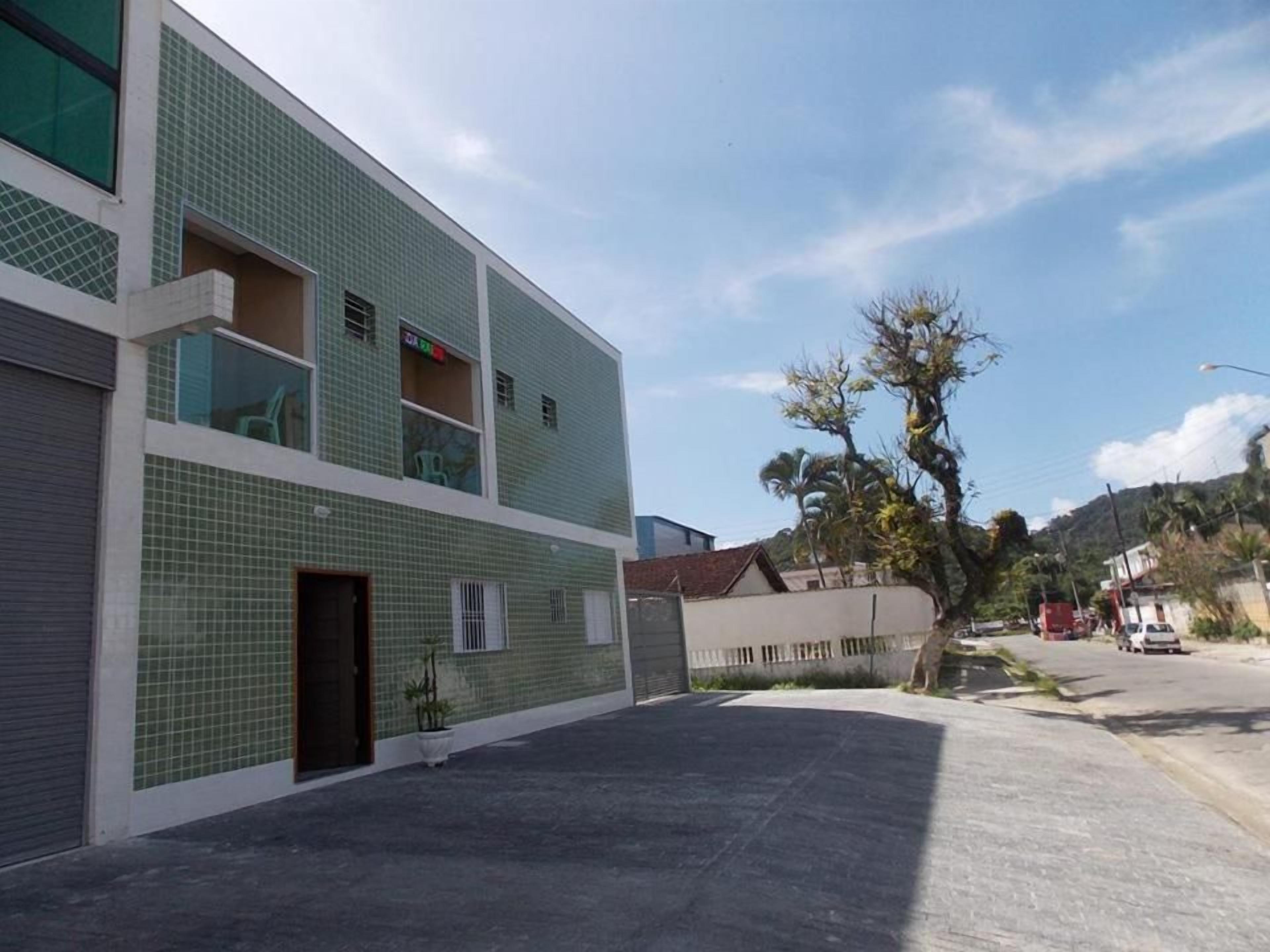 Um edifício com fachada em azulejos, entrada protegida por grades e céu claro.