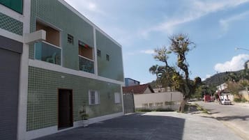 Um edifício com fachada em azulejos, entrada protegida por grades e céu claro.