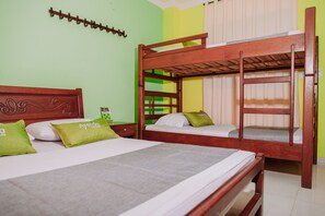 Habitación con literas, cabecera de madera y almohada verde con el texto 'Ayendo Hotels'.