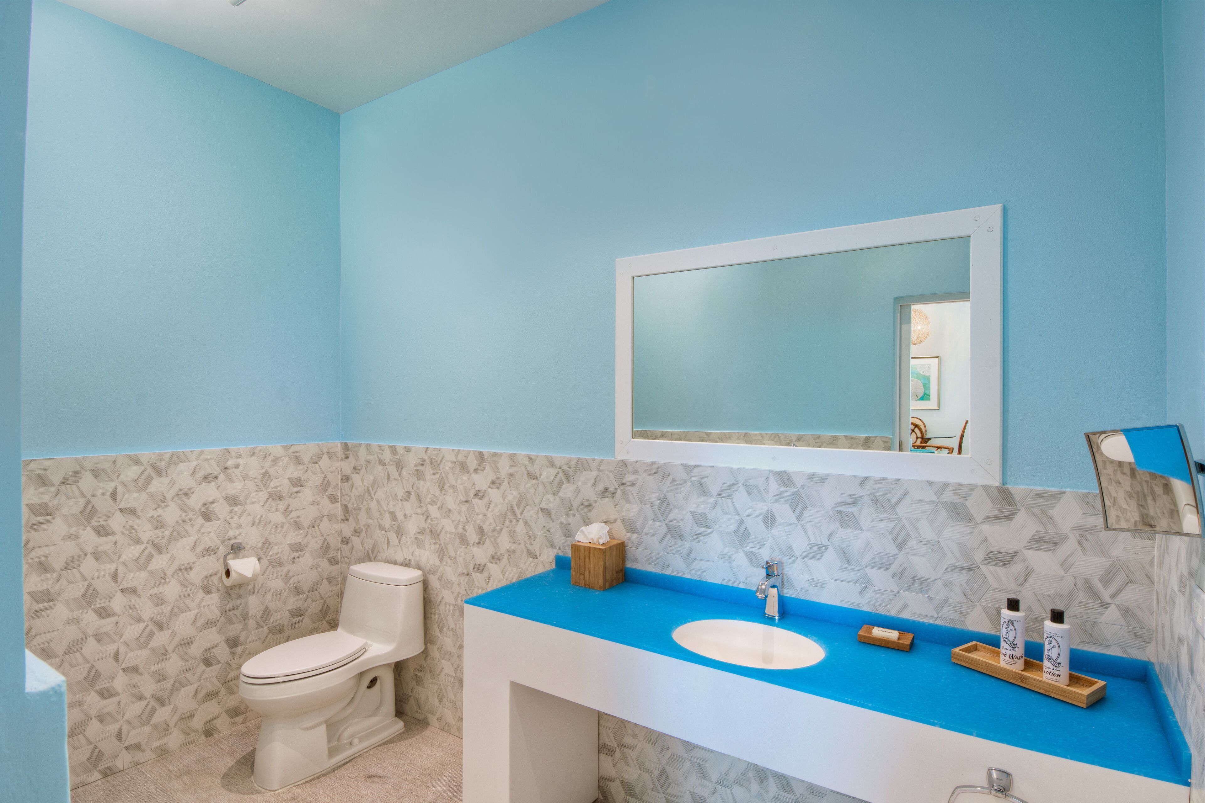 A bathroom with a toilet, a sink, and a mirror.