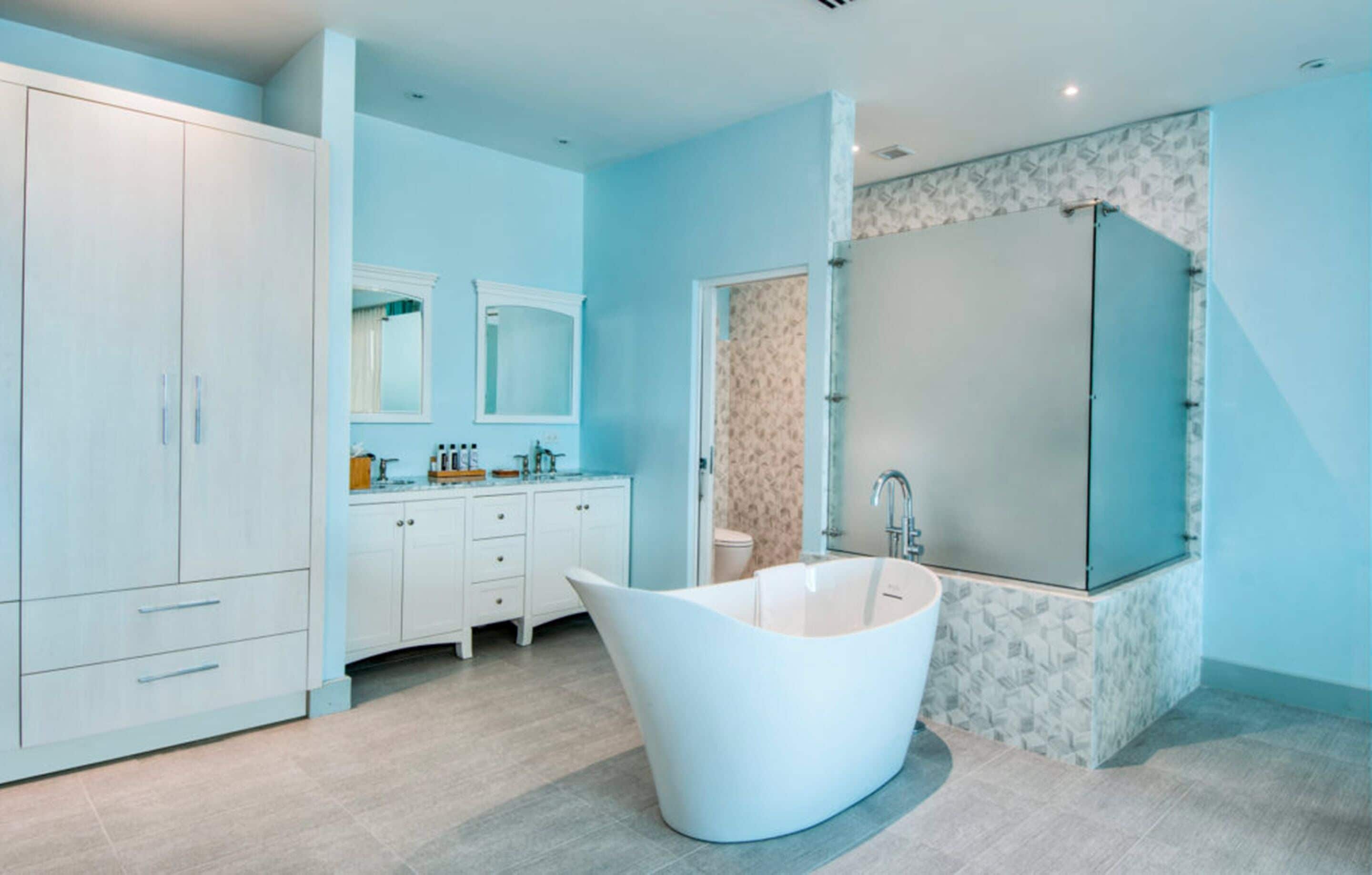 A modern bathroom with a freestanding bathtub, a large mirror, and a vanity with a sink and countertop.