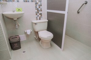 Une salle de bain avec des toilettes, un lavabo et une douche.