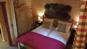A wooden room with a bed, a nightstand, a lamp, and a wardrobe. - Blockhaus Bodefall (Braunlage)