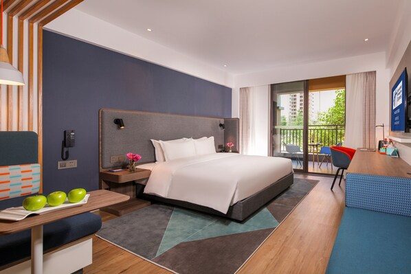 A modern hotel room with a large bed, a desk with a laptop, a chair, and a balcony with a view of the city. - Holiday Inn Express Chengdu East by IHG (Chengdu)
