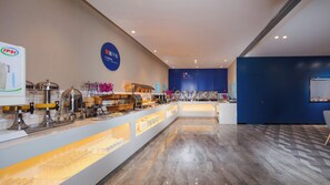 A buffet area with various food stations, a blue wall with text, and a patterned floor. - Holiday Inn Express Chengdu East by IHG (Chengdu)