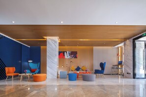 A modern lobby with a marble floor, wooden ceiling, and colorful seating arrangements. - Holiday Inn Express Chengdu East by IHG (Chengdu)