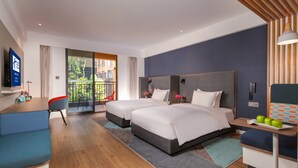A modern hotel room with two beds, a desk, a TV, and a balcony with a view of greenery. - Holiday Inn Express Chengdu East by IHG (Chengdu)