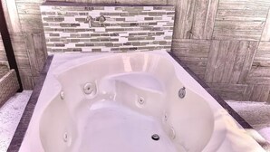 A spa tub with a stone mosaic wall behind it. - Loft con Alberca Climatizada/2 Exclusivos Jacuzzis Premium/Terraza/Grill/Wi-Fi (Lomas Tetela)