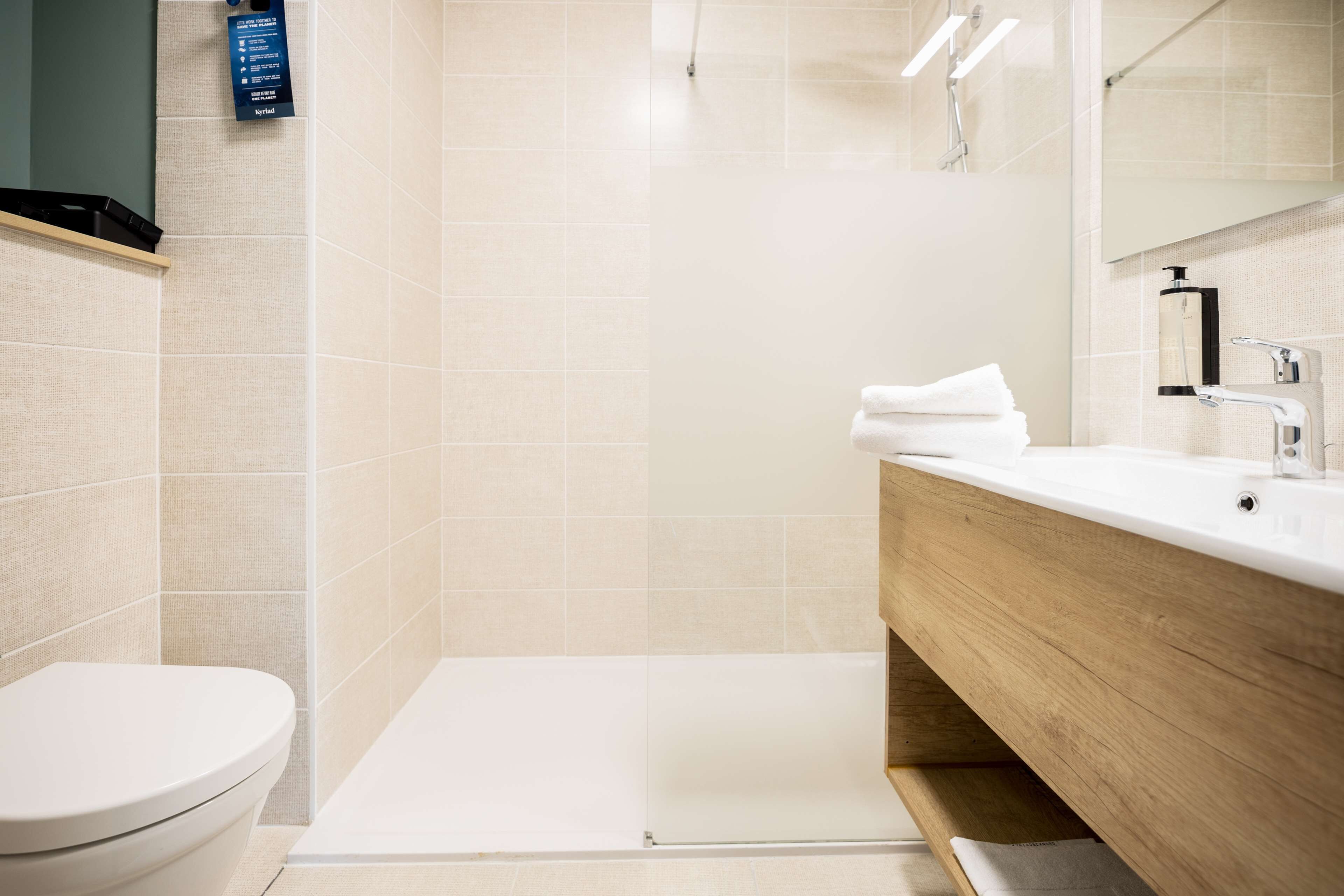 A modern bathroom with a toilet, sink, and shower area.