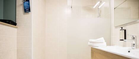 A modern bathroom with a toilet, sink, and shower area.