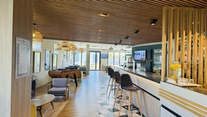 Zona de bar moderna con suelo a cuadros, techo de madera y taburetes.