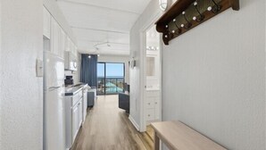 Une cuisine moderne avec des armoires blanches, un plan de travail en bois et un four encastré.
