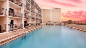 A multi-story hotel with a swimming pool, balconies, and sun loungers. - Beacher's Oceanfront Balcony Suite with onsite Front Desk and Staff (St. Augustine)