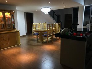 A dining area with a round table and chairs, a wooden cabinet, and a staircase in the background. - buzios season rental  (buzios)