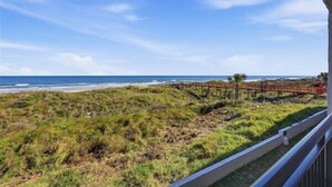 A coastal view from a balcony with a wooden walkway leading to the beach. - Beacher's Oceanfront Balcony Suite with onsite Front Desk and Staff (St. Augustine)
