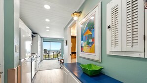 Una cocina con armarios blancos, encimera azul y un tazón verde.