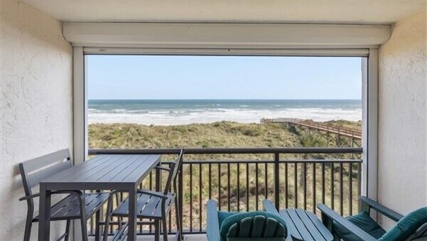 Un balcon avec vue sur la plage et l’océan.