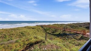 Un paysage côtier avec une promenade en bois menant à la plage.