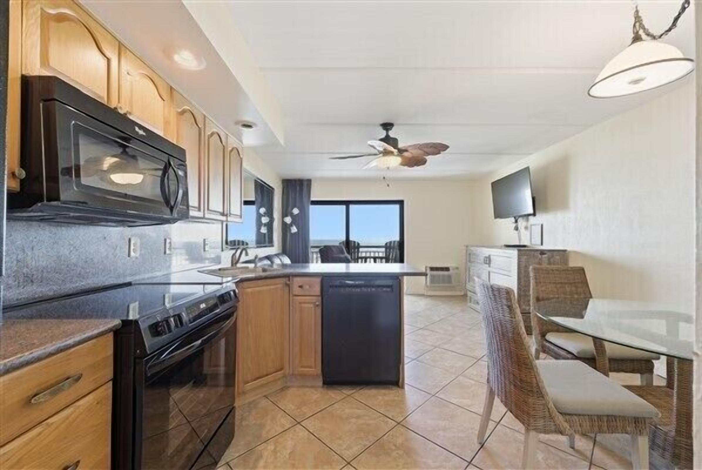 A modern kitchen with wooden cabinets, a built-in microwave, and a dishwasher.