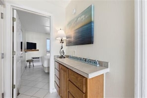 A bathroom with a sink, mirror, and towel rack. - Beacher's Oceanfront Balcony Suite with Onsite Front desk and staff (St. Augustine)