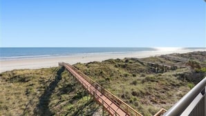 Une vue sur la plage avec une promenade en bois qui mène au rivage.