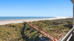 A beach view with a wooden boardwalk leading to the shore. - Beacher's Oceanfront Balcony Suite with Onsite Front desk and staff (St. Augustine)