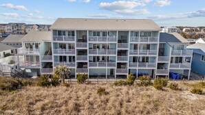 A multi-story hotel with balconies, a flat roof, and a view of the surrounding area.