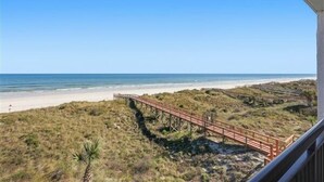 Une plage avec une promenade en bois qui mène au bord de l’eau.