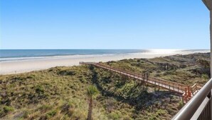 A beach view with a wooden boardwalk leading to the shore. - Beacher's Oceanfront Balcony Suite with Onsite Front desk and staff (St. Augustine)