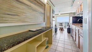 A modern kitchen with a marble countertop, a large window, and a view of the sea. - Beacher's Oceanfront Balcony Suite with Onsite Front desk and staff (St. Augustine)
